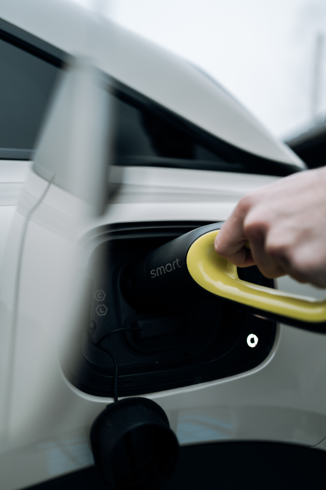 Hand plugging a charging cable into the Smart #3 Premium.